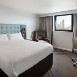 Hotel room with a double bed featuring soft furnishings and decorative cushions.