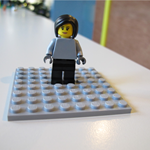 A Lego woman standing on a white table.