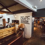 The interior of Craft And Doug with a view of the kitchen and the seating area.