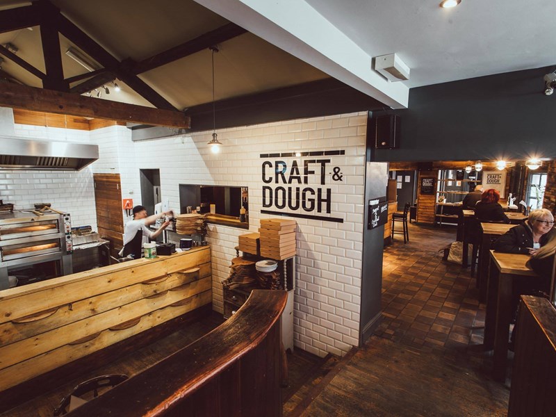 The interior of Craft And Doug with a view of the kitchen and the seating area.