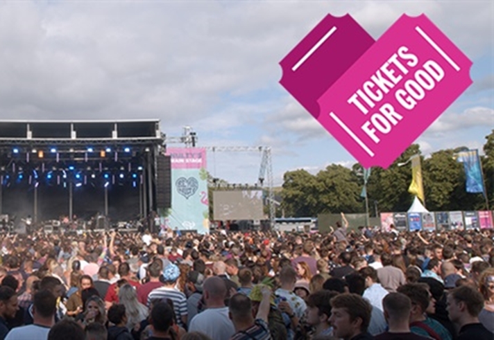 A crowd at a music festival in front od a stage.