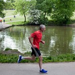 A man running on a path that goes around one of the ponds at Graves Park.