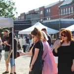 People looking through the stalls at Rex Market on a sunny day.