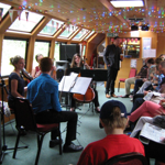Inside the A&G Passenger Boat, with people sat listening to a string quartet.