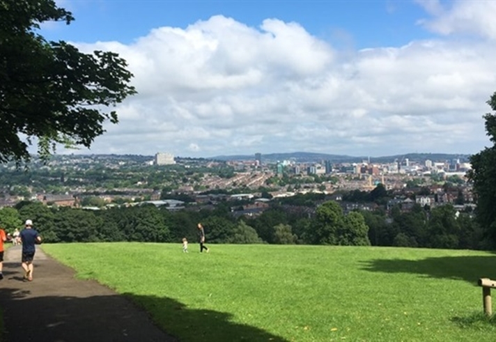 Two people running in a park that overlooks Sheffield city centre.