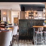 Charming bar area at The Florentine with wooden counter, ambient lighting, and seating
