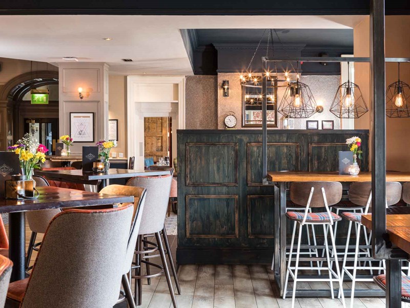 Charming bar area at The Florentine with wooden counter, ambient lighting, and seating