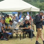 People sat at a table under a gazebo, eating and drinking, at a previous years Walkley Festival.