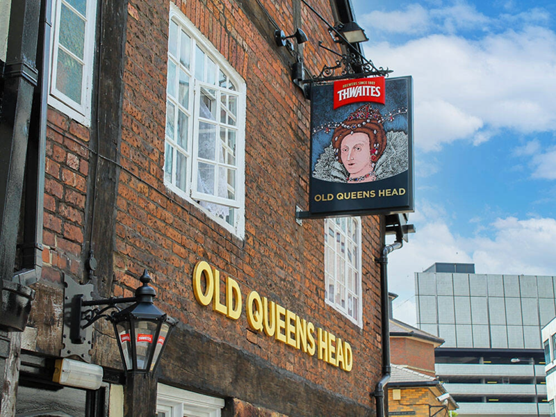 The exterior of The Old Queens Head with their pub sign.