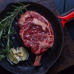 A steak in an iron griddle.