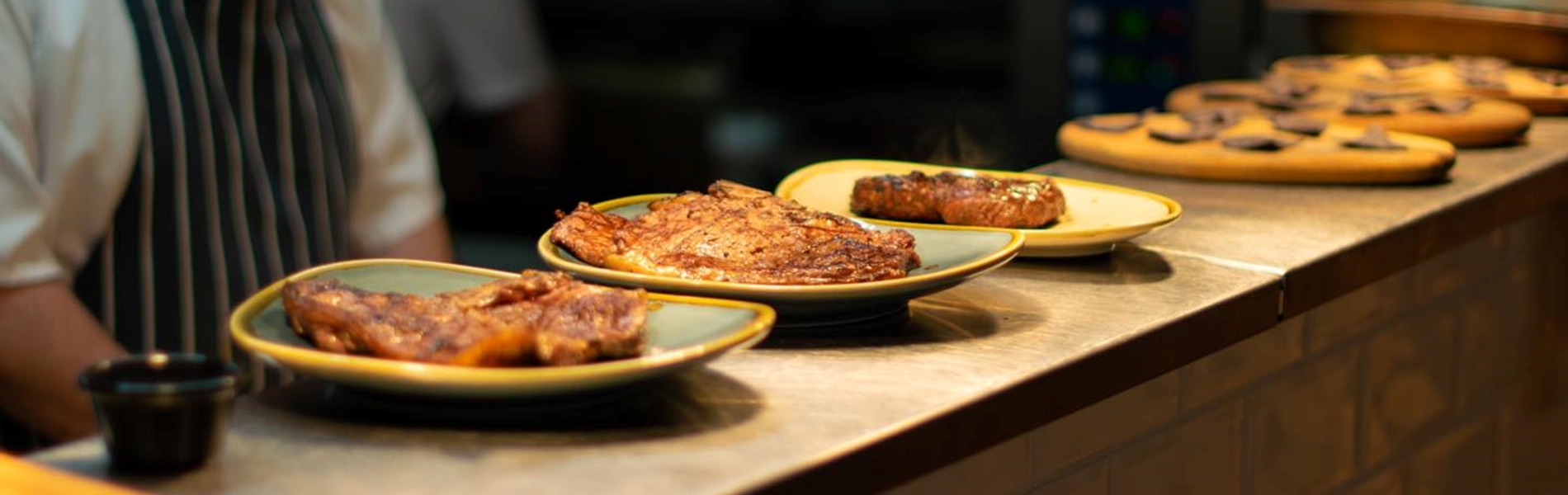 Rows of dishes on a counter top waiting to be served.