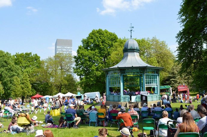 Crowds of people sat listening to music from the bandstand at Weston Park May Fayre