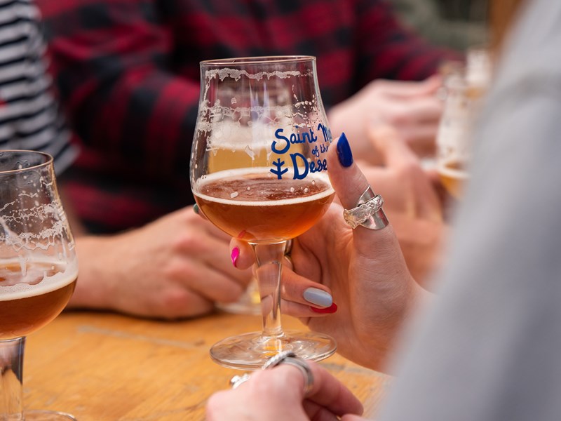 People enjoying a beer outdoors at The Brewery of St Mars of the Desert.