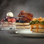 Three plates filled with stacks of pancakes.