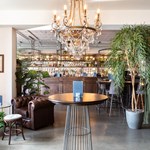 The interior of The Lost & Found, there are lots of plants and a chandelier hangs from the ceiling.