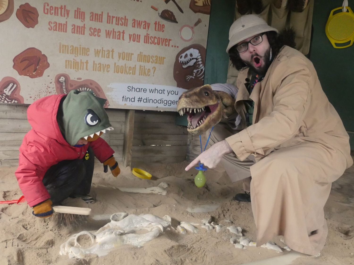  A child digging up some dinosaur bones in a sandpit.