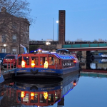 The A&G Passenger Boat on the canal at night.