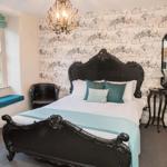 Spacious double bedroom with a large bed, ample floor space, bedside tables