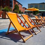 A row of orange deckchairs in the outside seating area at the Forum Kitchen + Bar.