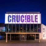 The exterior of the Crucible Theatre at night, with its illuminated sign, as seen from Tudor Square.