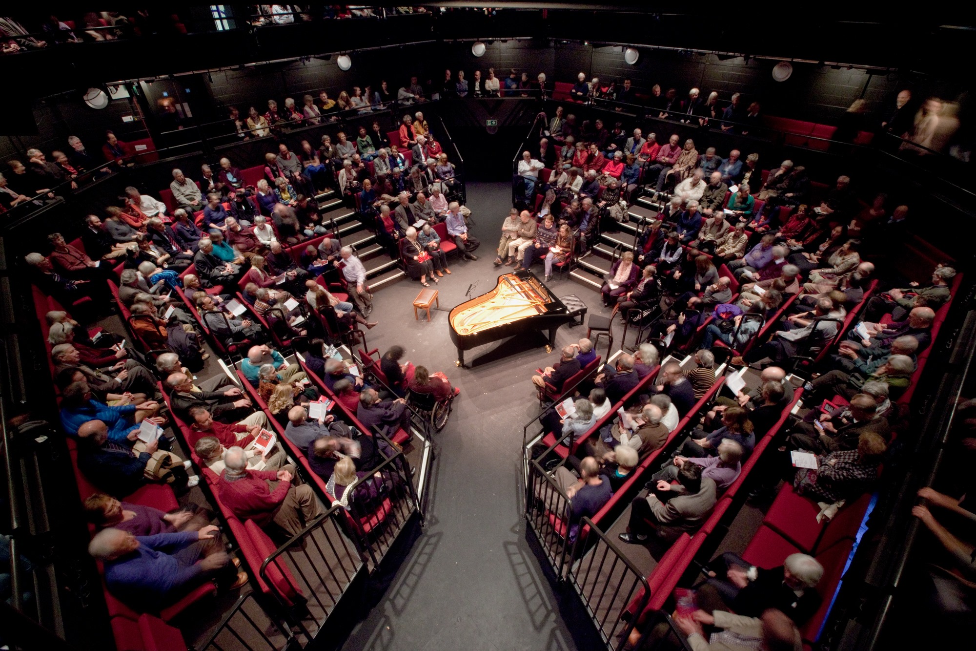 A packed house at the Crucible Theatre waits in anticipation for a classical concert to start. In the centre of the stage stands a grand piano.