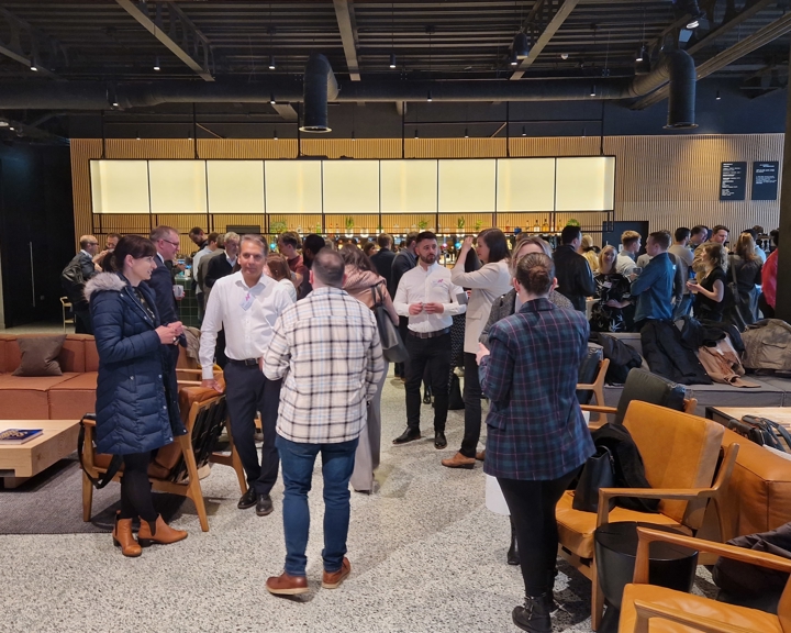 A conferencing space is filled with people chatting.
