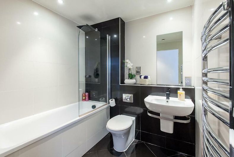 Modern black and white bathroom with sleek fixtures and contrasting tile design.