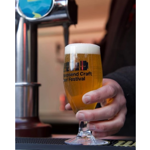 A glass of beer being poured from a beer pump.