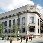 Exterior of Sheffield Central Library on a sunny day with people walking past