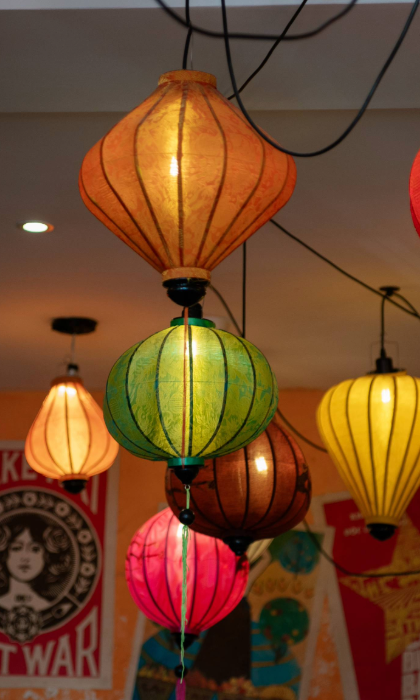 An array of brightly coloured Vietnamese lanterns hang from a ceiling.