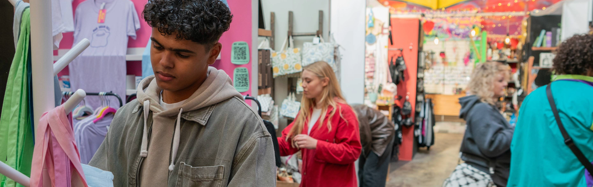 People looking at various stalls at an indoor market.
