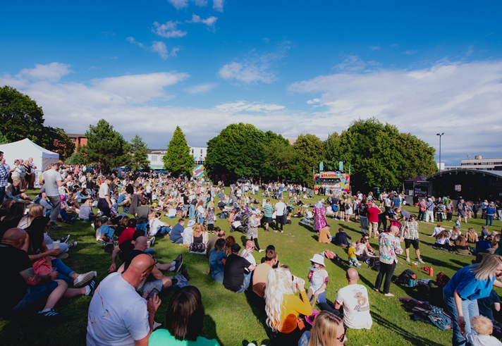 Blue skies over Devonshire Green as groups of people sit in the sunshine watching performances on the Fringe main stage