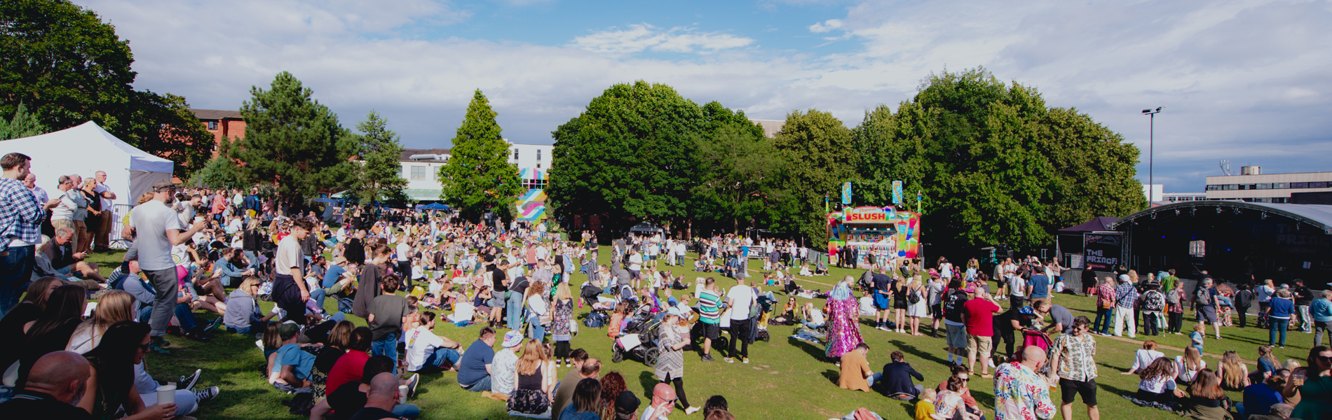 Blue skies over Devonshire Green as groups of people sit in the sunshine watching performances on the Fringe main stage 