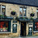 Outside The Old Original Bakewell Pudding Shop, an old stone building.