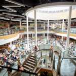 The multi-level Oasis Dining Quarter at Meadowhall, with busy seating areas, central staircases, glass balustrades and a circular skylight above.