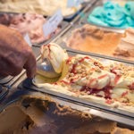 Rows of tubs of different flavour ice creams.
