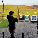 Three people doing archery at the Ringinglow Archery Target Sports Centre.