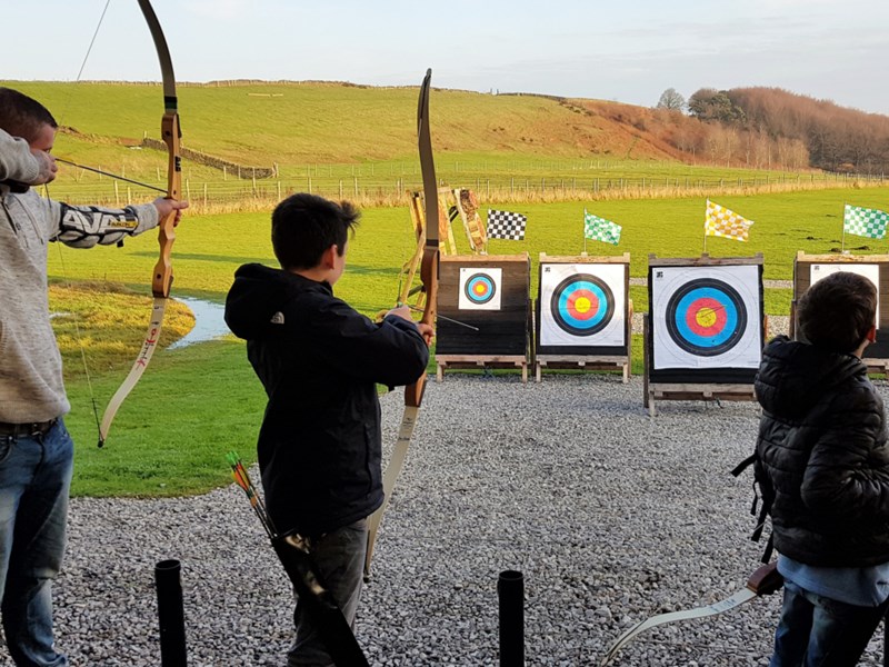 Three people doing archery at the Ringinglow Archery Target Sports Centre.