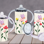 Three drinkware items with interchangeable lids and handles, decorated with a minimalist floral design of pink, yellow, and red flowers with green stems, and purple butterflies on a cream background. The set includes a sippy cup, a tumbler with a straw, and a cup with handles.