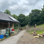 A wooden building with a covered veranda at Rivelin Valley Dog Park.