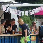 A person buying a beer at an outdoor bar at a previous years Walkley Festival.