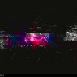 A band plays live on stage in front of an audience.