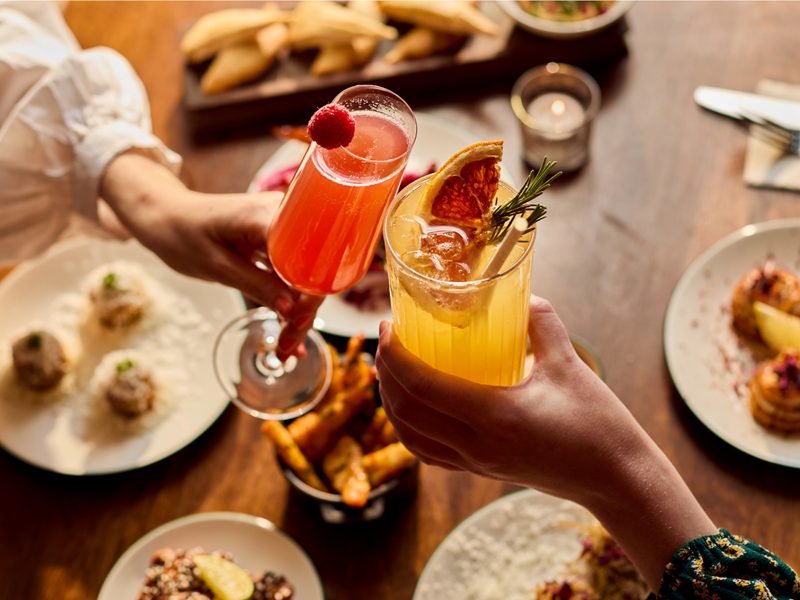 Two people dining at Cosy Club, and enjoying their cocktails.
