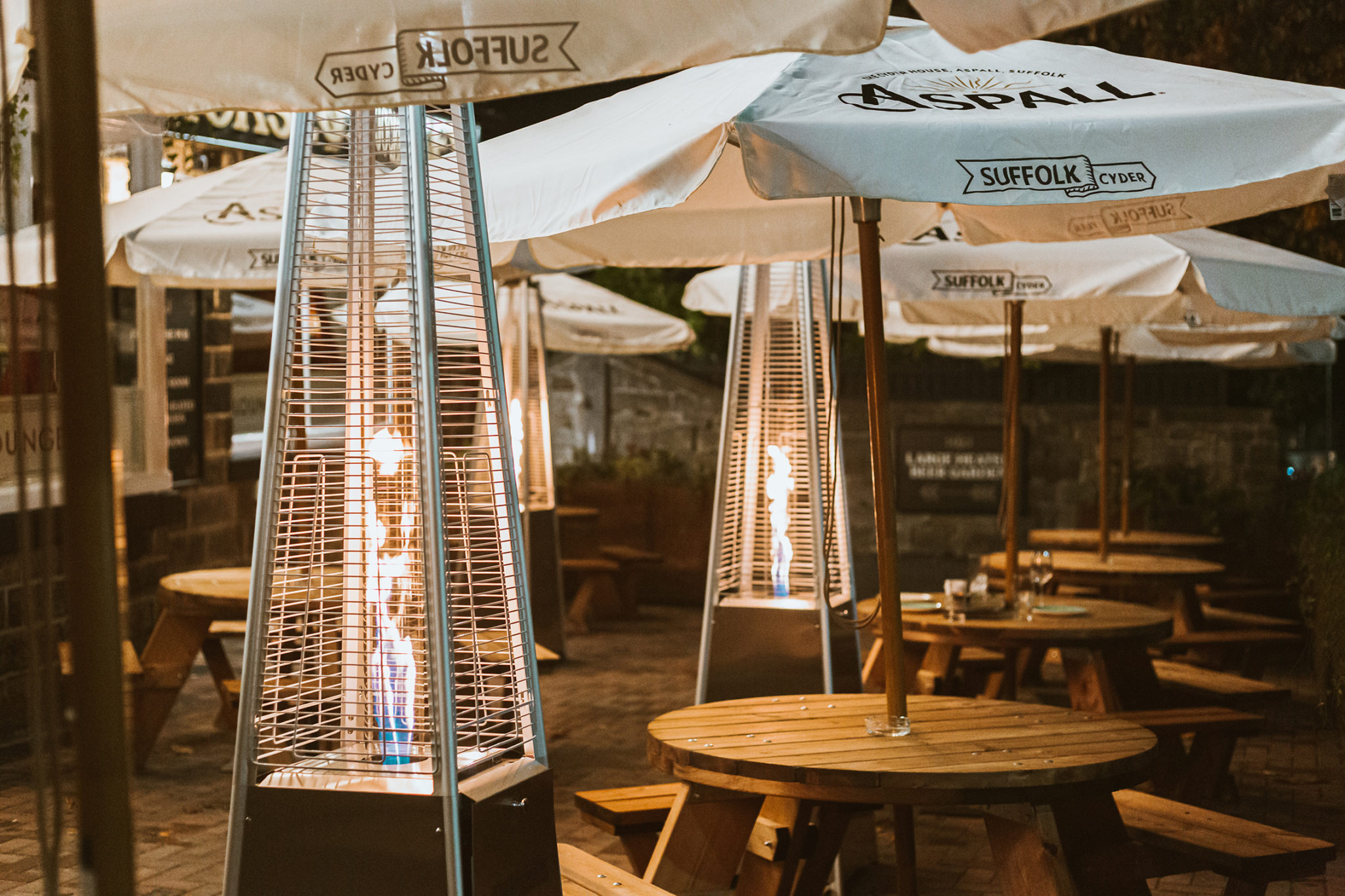 The beer garden at The Horse & Jockey with tables, umbrellas and heaters.