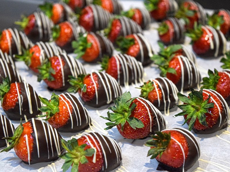 A tray of strawberries that have been drizzled in chocolate.