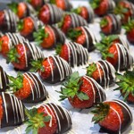 A tray of strawberries that have been drizzled in chocolate.
