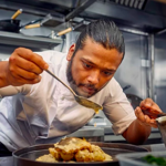 A chef preparing food in the kitchen at Lavang.