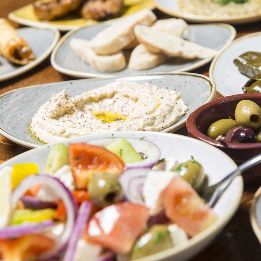 Seven plates of Turkish food laid out on a table.