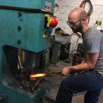 Two men hard at work in a forge.