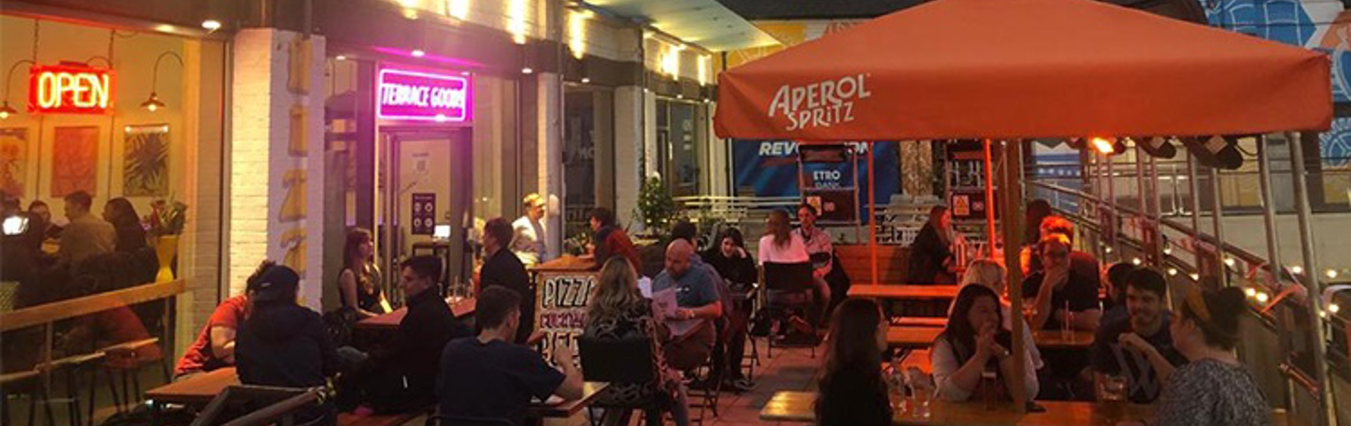 People eating outside, at night, at a cafe.